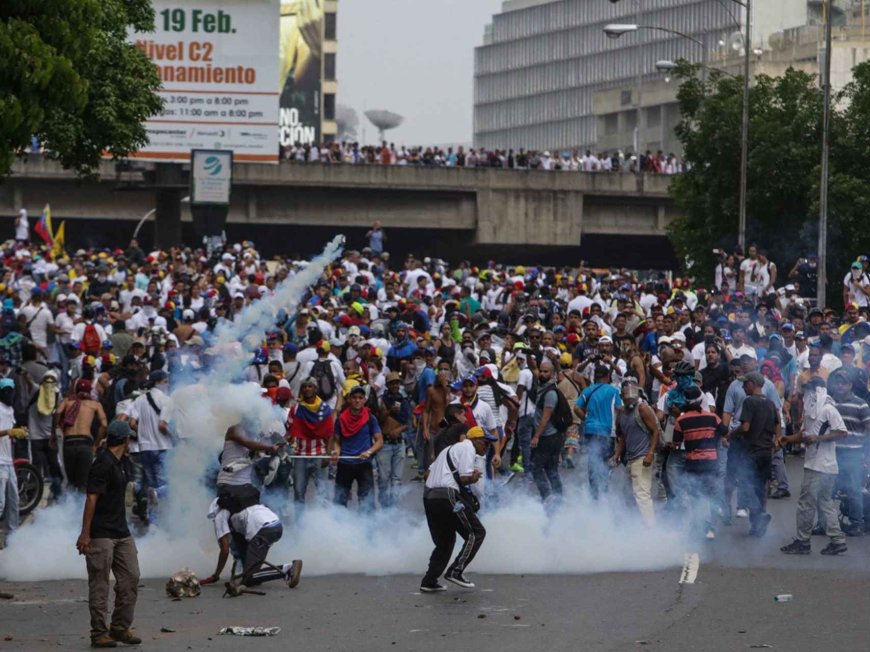 Un grupo de manifestantes enfrentándose con la policía este miércoles en Caracas.