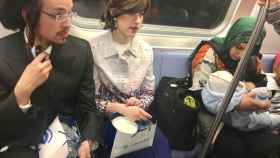Dos judíos sentados junto a una mujer musulmana dando de comer a su bebé.