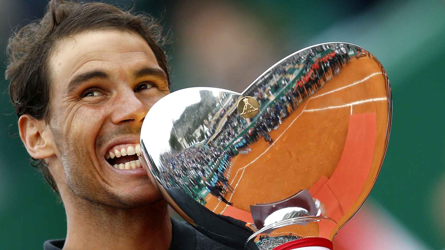 Nadal, mordiendo el título de campeón de Montecarlo.
