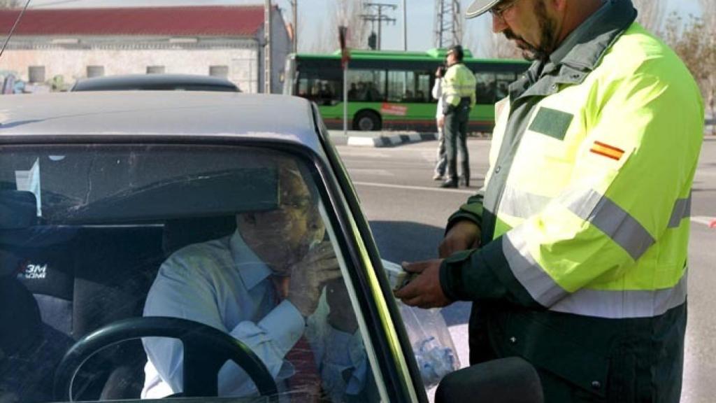 Un agente realiza un control de alcolhemia a un conductor.