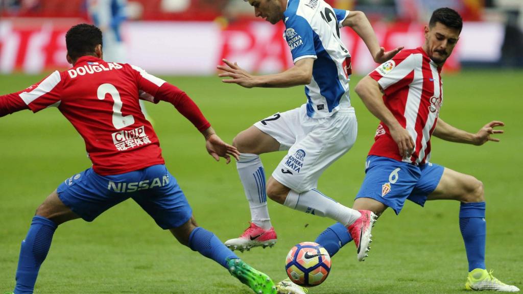 Douglas intenta robarle un balón a Aaron Martín.