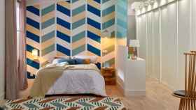 Habitación que combina papel pintado en la pared y una alfombra con diseño geométrico. | Foto: Leroy Merlin.