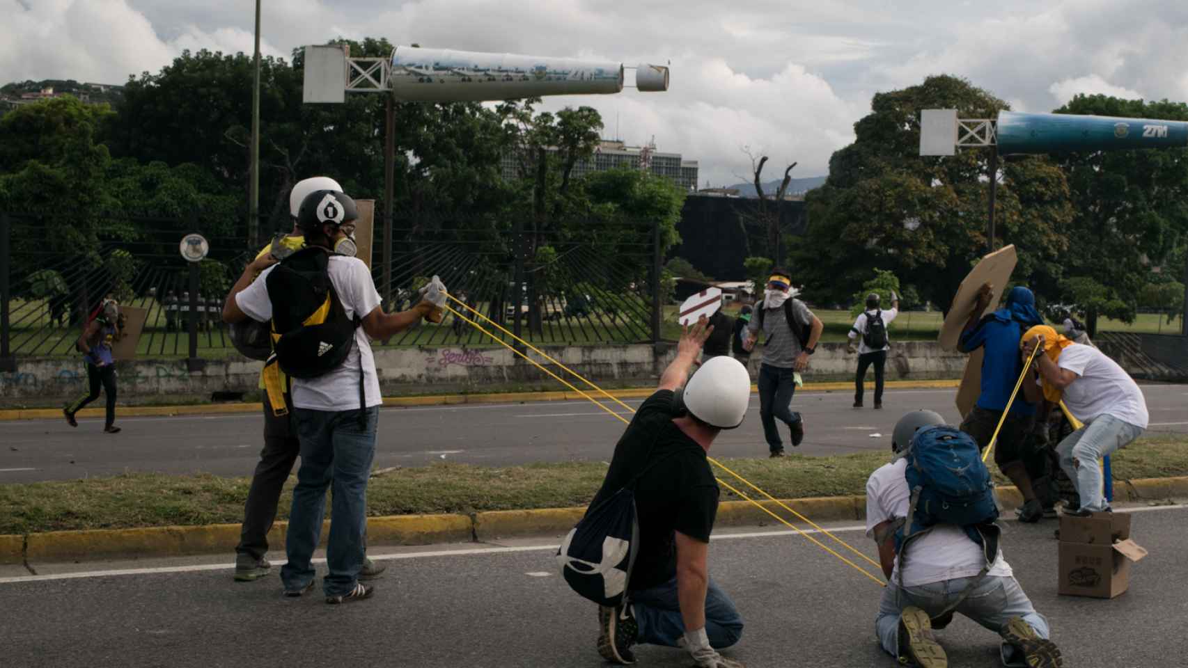 Manifestantes se preparan para lanzar una piedra en las calles de la capital venezolana