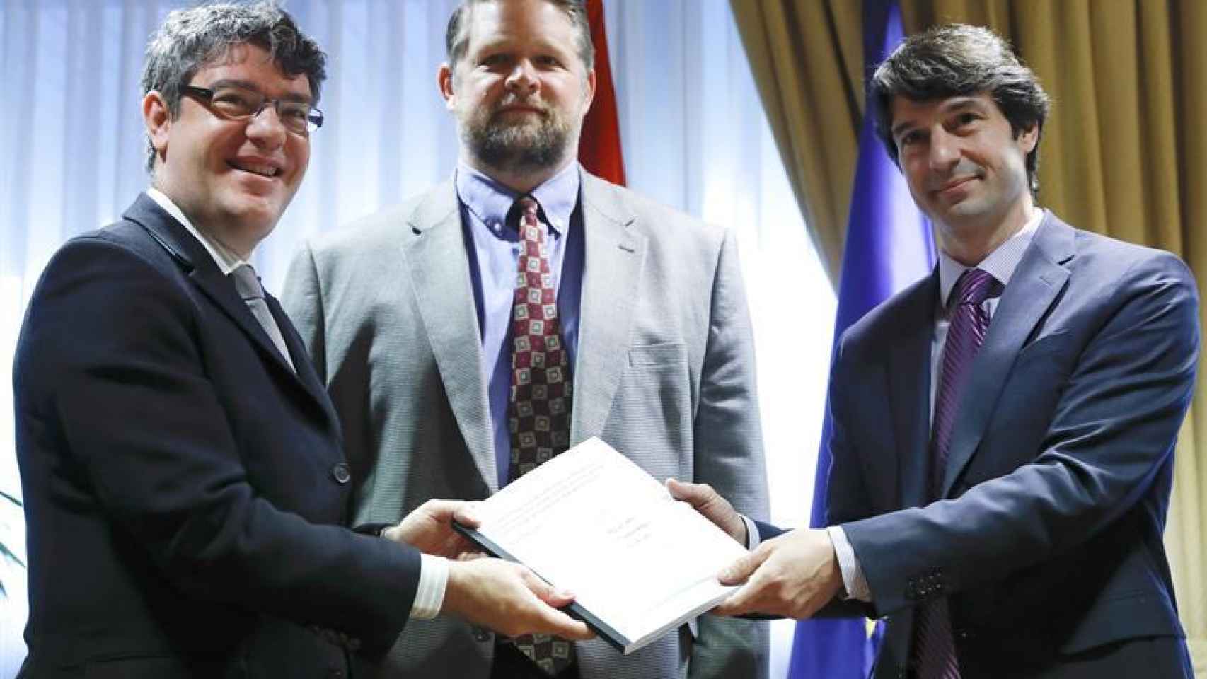 El ministro Álvaro Nadal recibe el informe de los representantes de Harvard y el MIT.