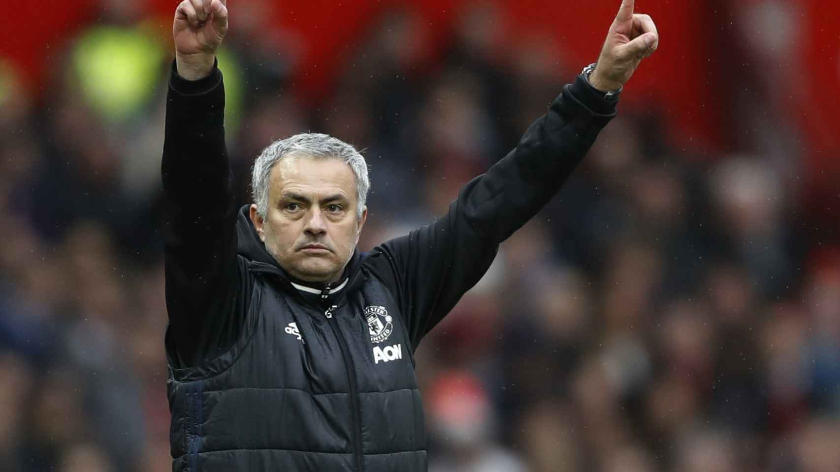 Mourinho levanta los brazos durante un partido con el United.