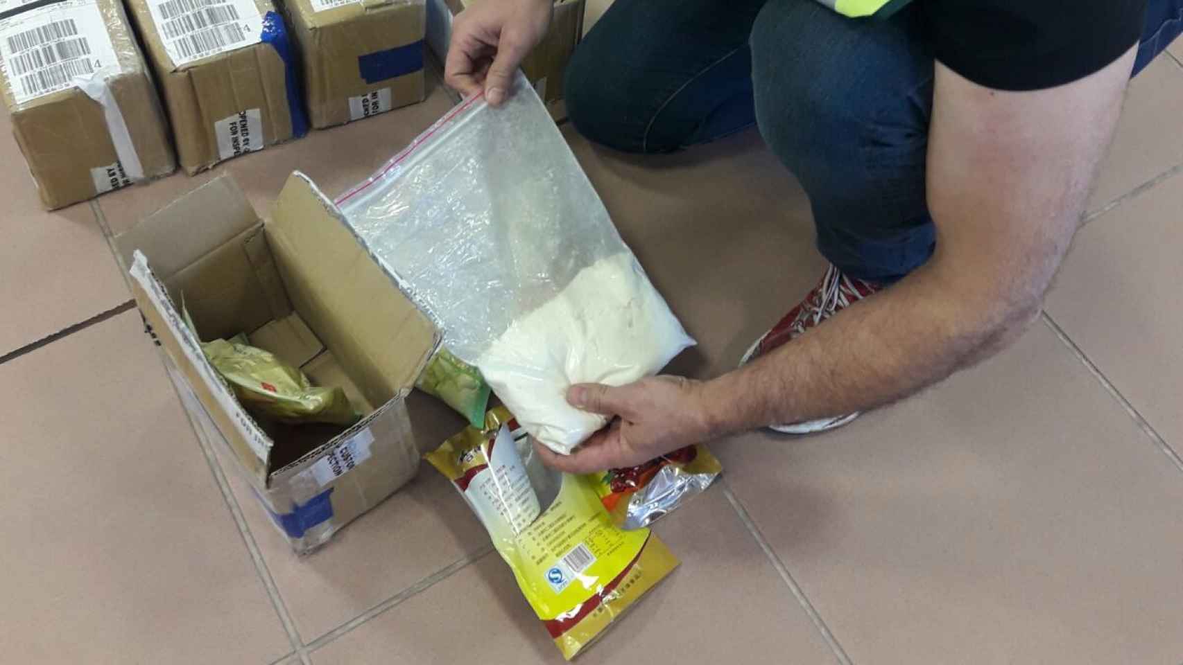Un agente de la Guardia Civil de Alicante observa el contenido de la bolsa de droga.