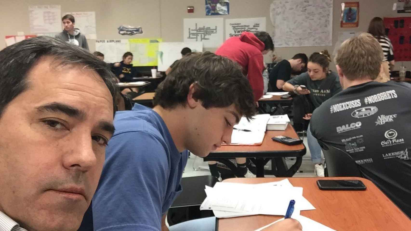 Brad Howard sentado en la clase del instituto junto a su hijo.