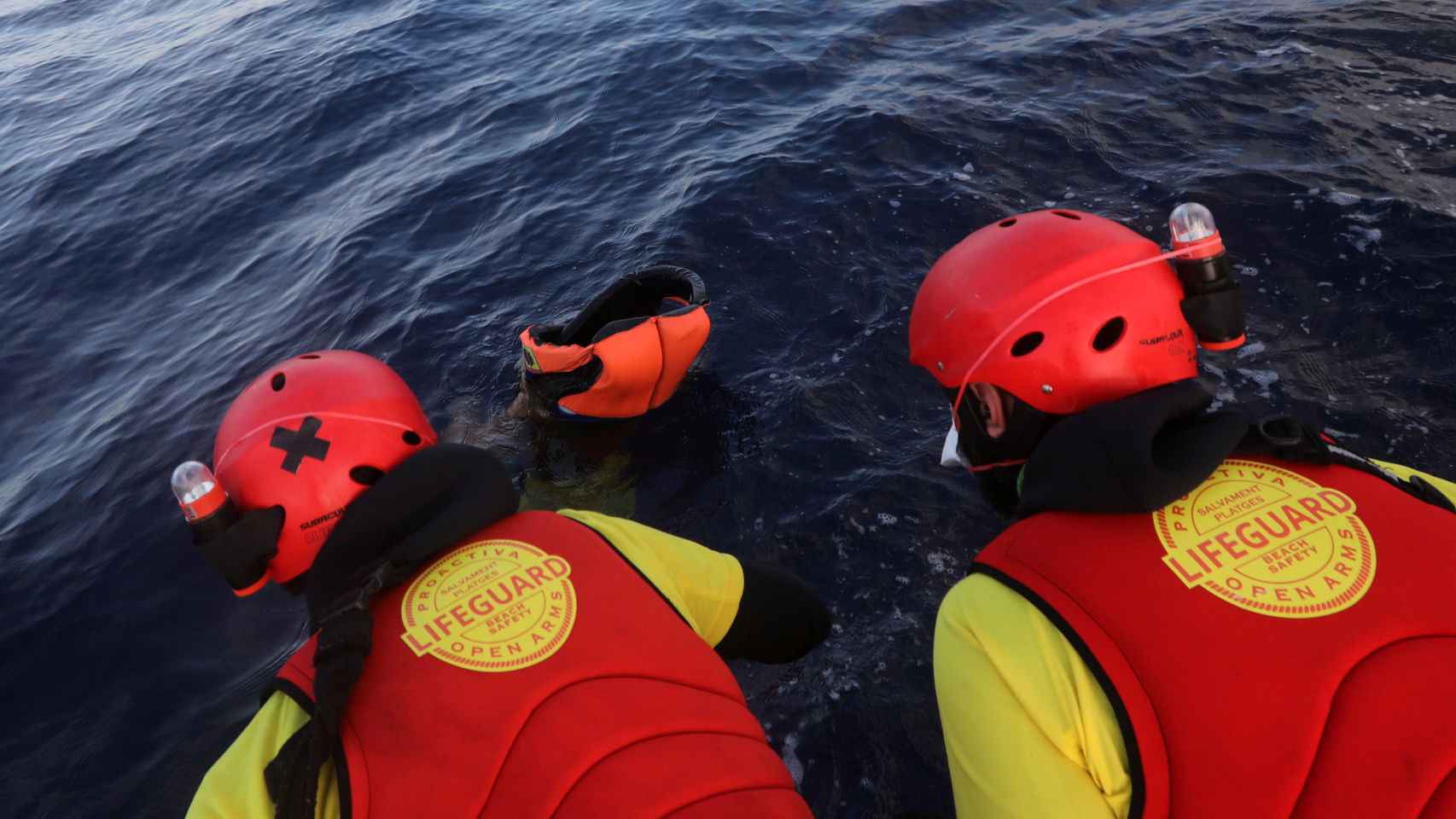 Dos integrantes de la ONG Proactiva Open Arms sacando a un cuerpo del agua.