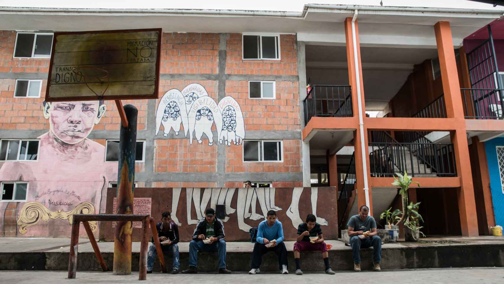 Varios hombres almuerzan durante su estancia en el refugio de migrantes de Tenosique
