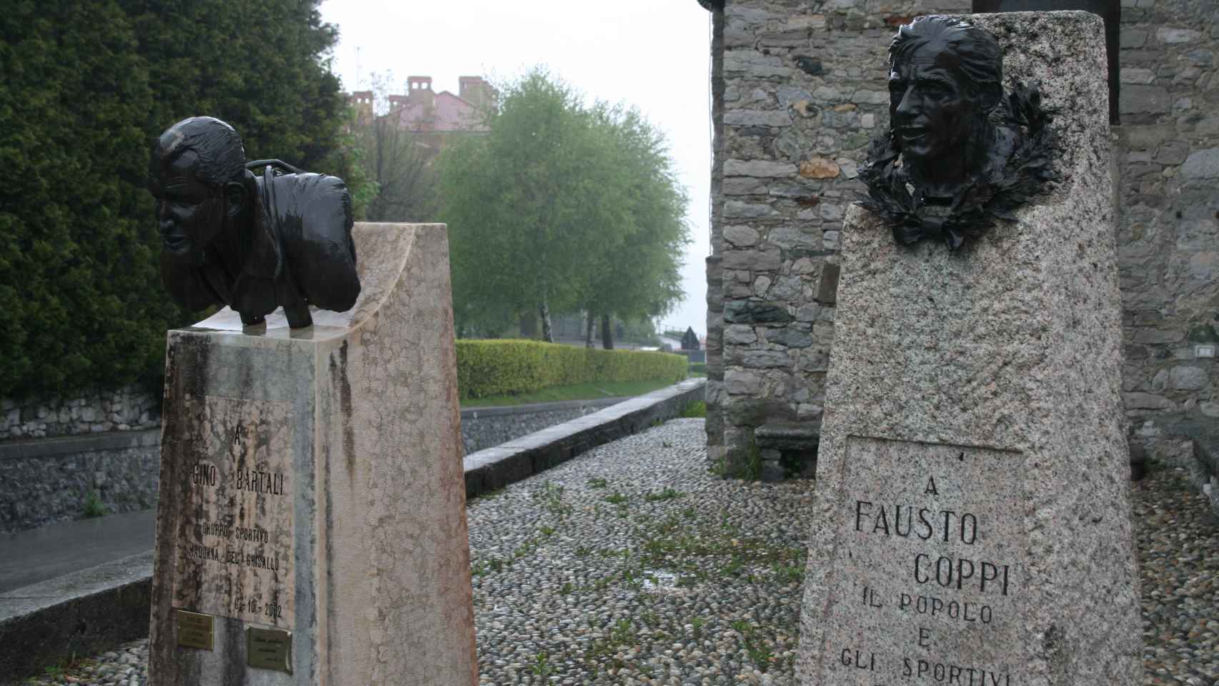 Los bustos de Gino Bartali y Fausto Coppi presiden la entrada a la iglesia.