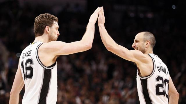 Pau Gasol y Manu Ginóbili chocan durante un partido .