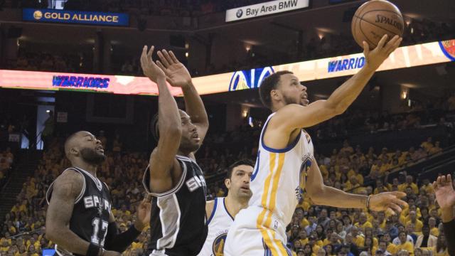 Curry intenta anotar ante Leonard.