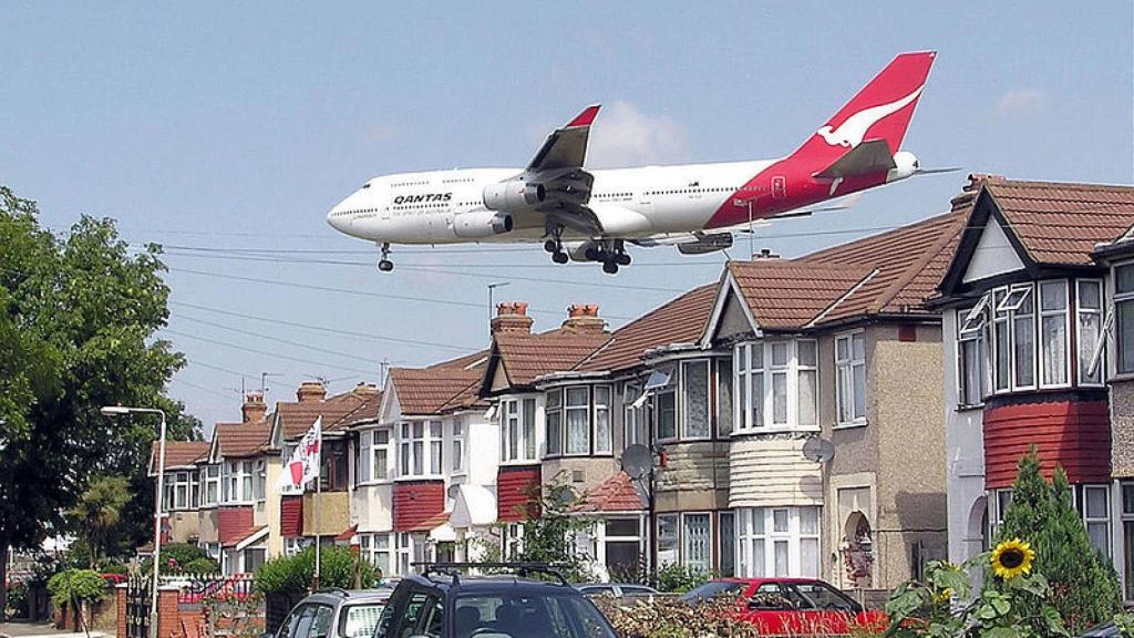 Un avión sobrevuela un barrio.