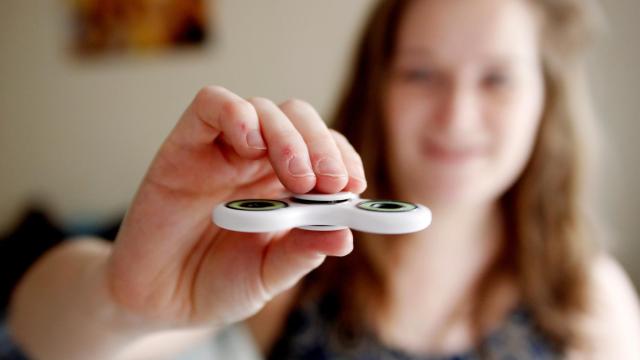 Una niña sostiene entre sus dedos un modelo del 'fidget spinner'.