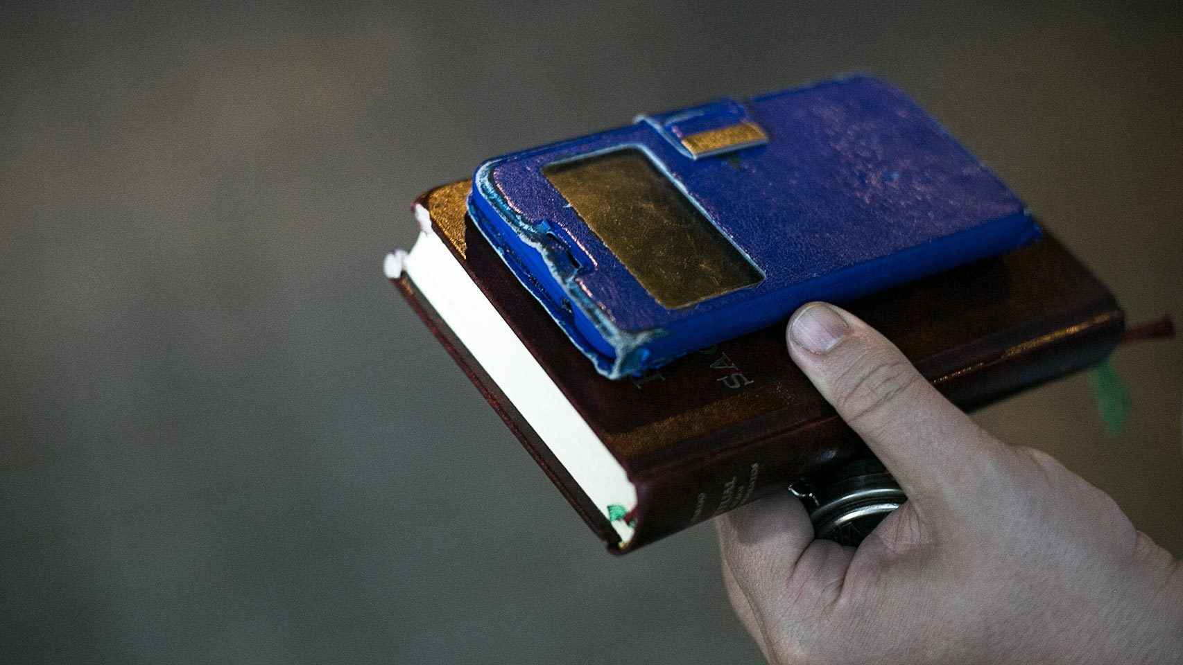 El móvil en el que el padre David atiende las llamadas de urgencia y su libro de sacramentos.