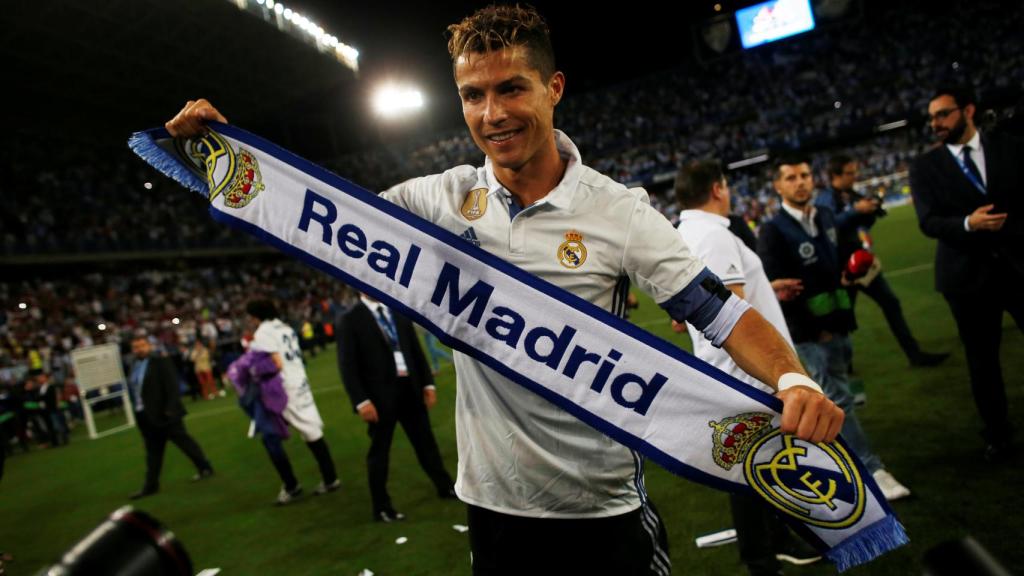 Cristiano Ronaldo posa con una bufanda del Real Madrid.