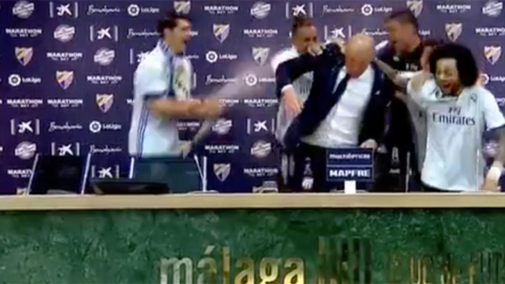 Los jugadores del Real Madrid bañan a Zidane durante la rueda de prensa