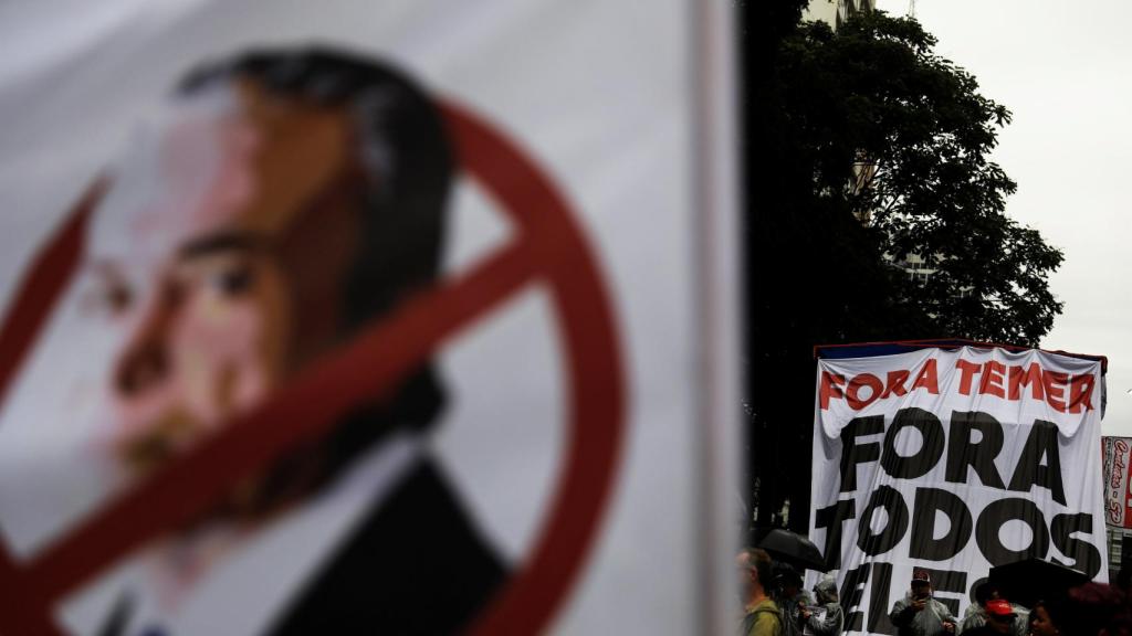 Manifestantes portan pancartas en contra de Temer.
