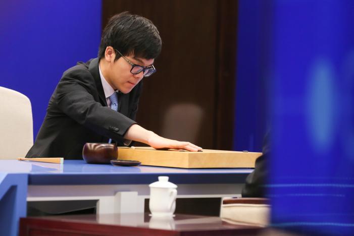 Chinese Go player Ke Jie puts a stone against Google's artificial intelligence program AlphaGo during their first match at the Future of Go Summit in Wuzhen