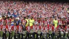 Los veteranos del Atlético de Madrid y los jugadores actuales posan con las copas.