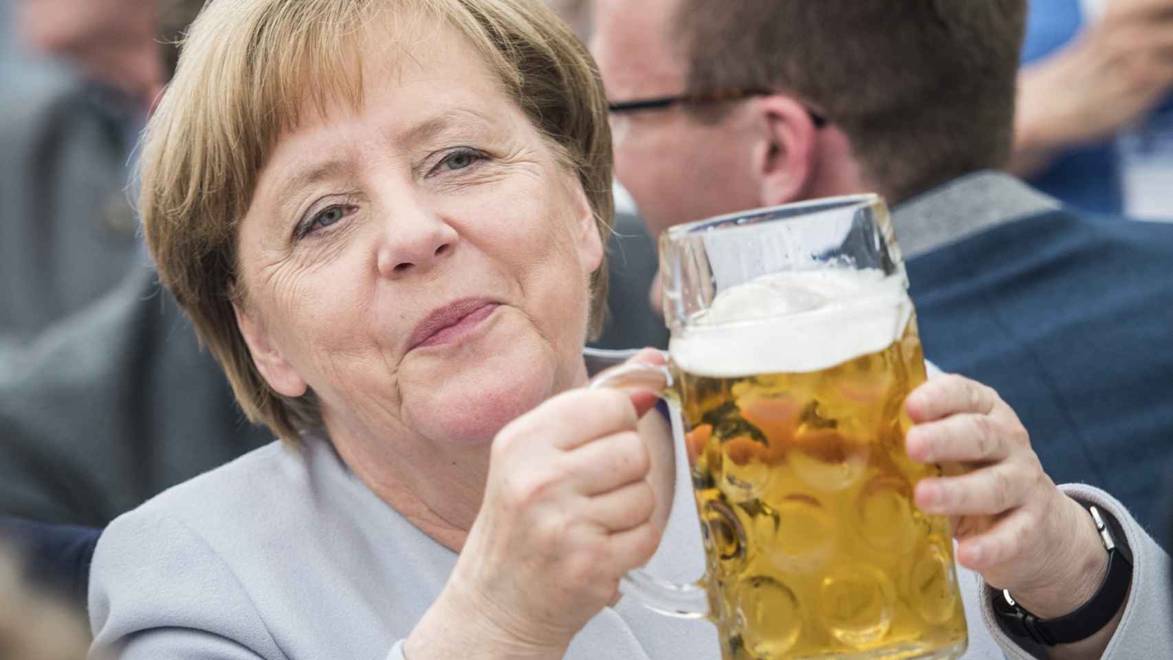 Merkel bebe una cerveza durante un acto de su partido.