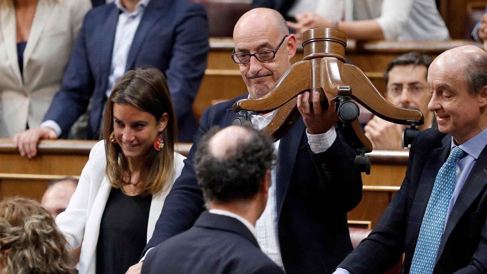 El diputado de Ciudadanos Félix Álvarez, Felisuco, entrega a un ujier las patas rotas del escaño de Toni Roldán