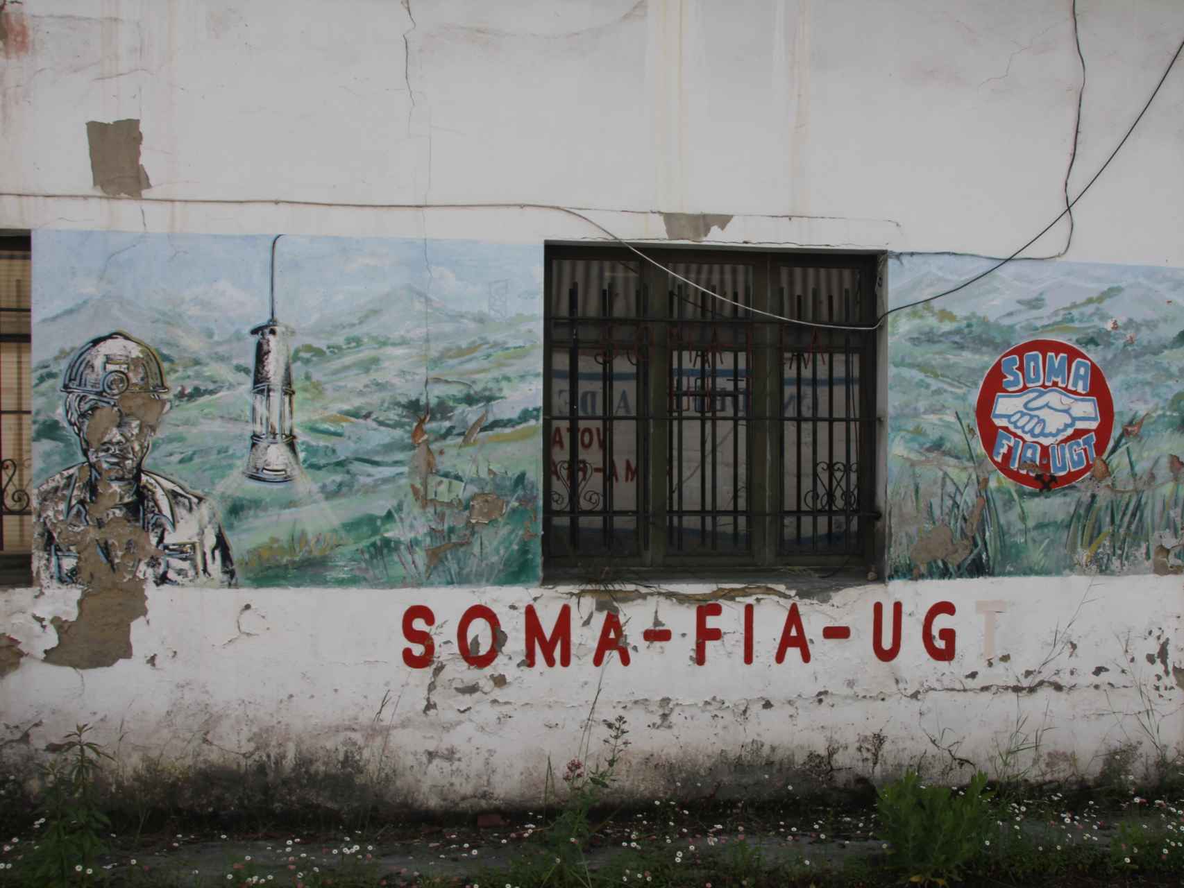 En Pozo Candín, la mina más próxima de Tuilla y hoy abandonada, aún lucen pintadas en favor del SOMA-UGT.