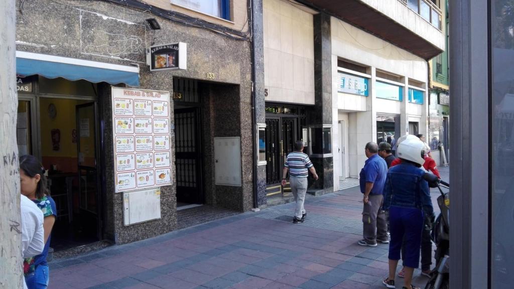 Dos hombres hacen guardia ante la puerta del 133 del Paseo de las Delicias