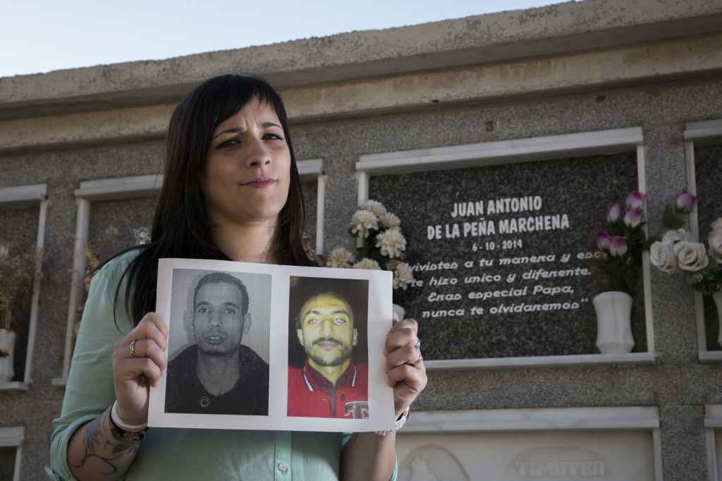 Dafne sostiene una imagen de los asesinos de su padre frente a su tumba.