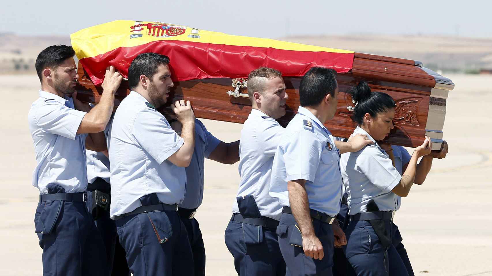 Varios agentes portan el féretro de Echeverría con la bandera de España.