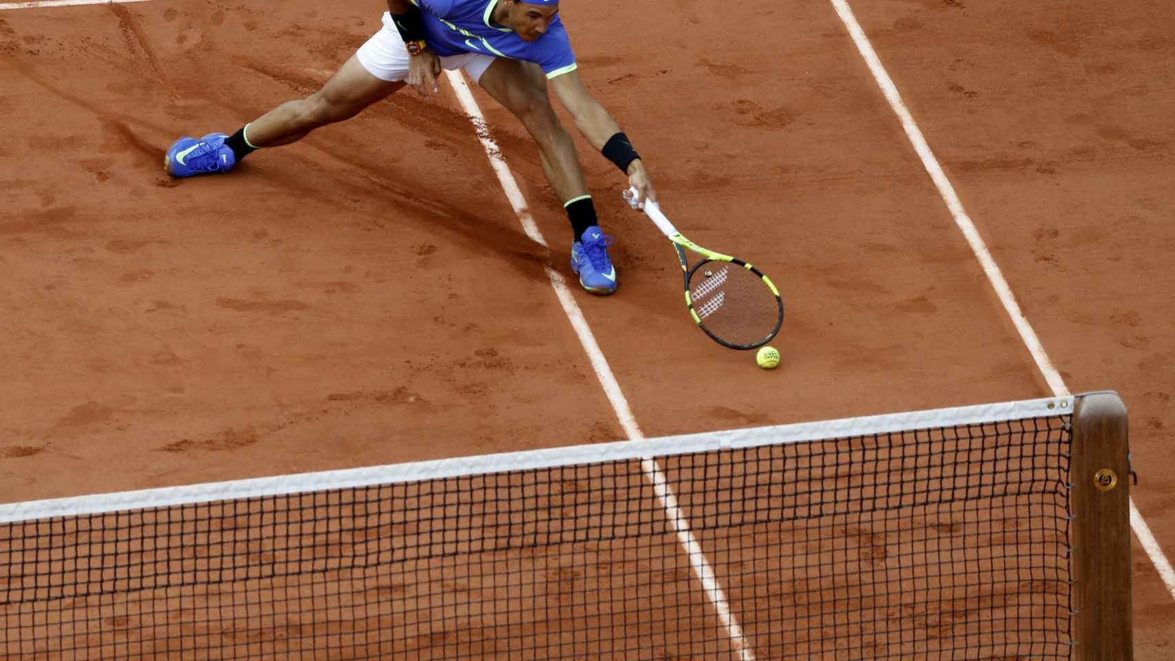 Nadal, persiguiendo una bola en un partido de Roland Garros.