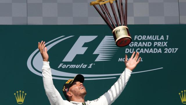 Hamilton lanza el trofeo conseguido en Montreal.