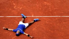 Nadal, tirado sobre la tierra batida tras ganar su décimo Roland Garros.