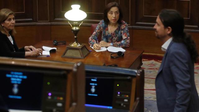 Dos taquígrafas, ante Pablo Iglesias en el centro del hemiciclo del Congreso de los Diputados.