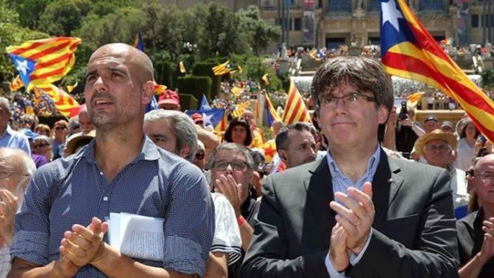 Guardiola, exentrenador del Barça (i), junto al presidente Carles Puigdemont (d) en el acto en favor del referéndum del 1-O.