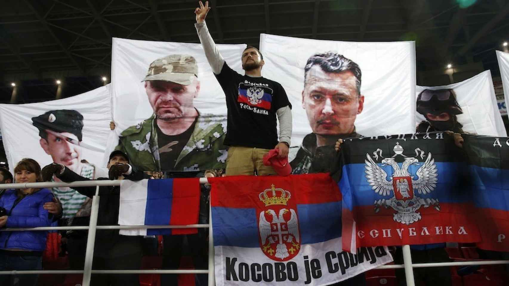 Aficionado ruso junto a una bandera de ‘Kosovo es Serbia’ y otra de la ‘República Popular de Donest’.
