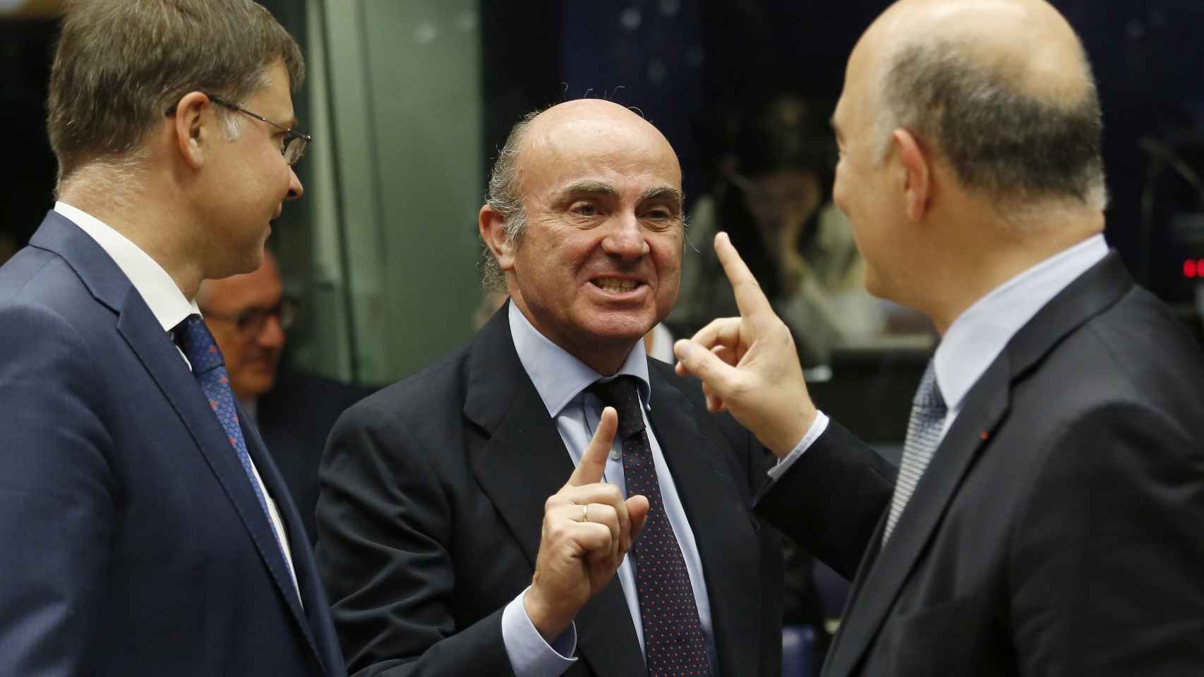 Guindos saluda a Moscovici y Dombrovskis durante la reunión del Eurogrupo