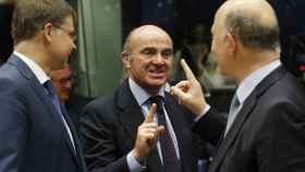 Guindos saluda a Moscovici y Dombrovskis durante la reunión del Eurogrupo