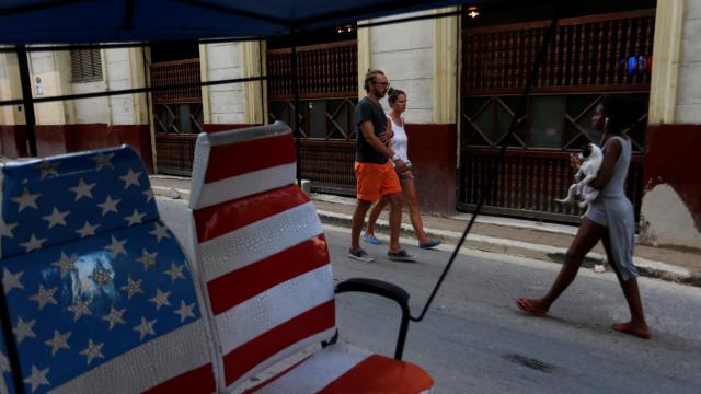 Dos turistas pasean por una calle de La Habana.