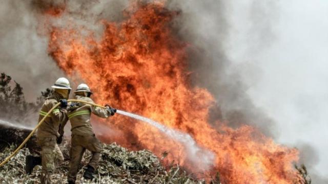 Dos bomberos tratan de apagar una lengua de fuego el pasado fin de semana.