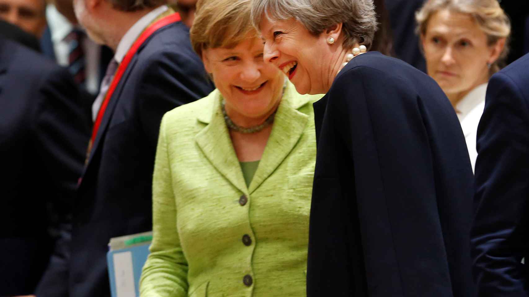 Merkel conversa con May durante la cumbre de verano