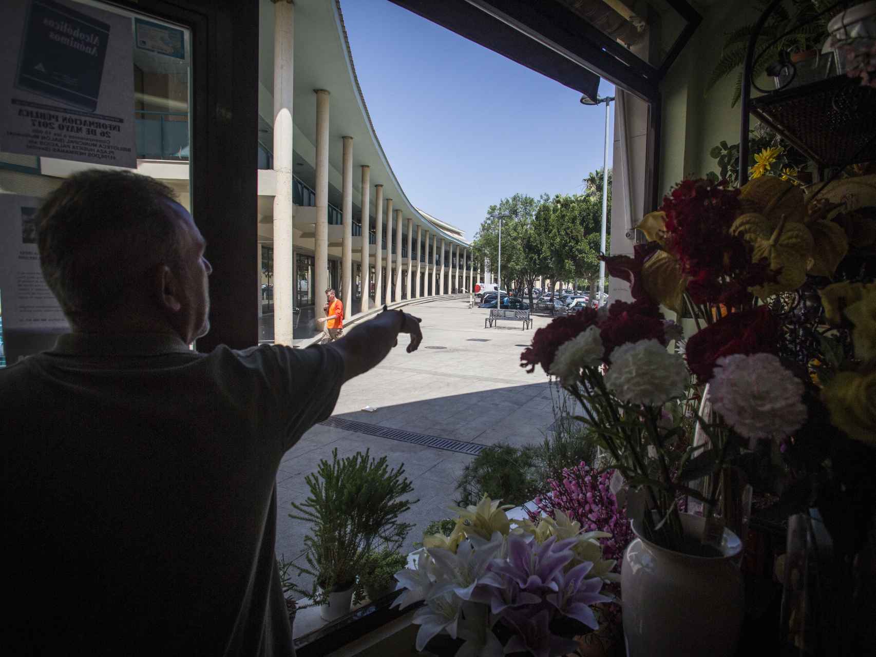 Un empleado de una floristería mostrando el lugar que frecuentaba Luis Miguel Briz Torrico los días previos al asesinato, hablando desde su móvil de manera enérgica.