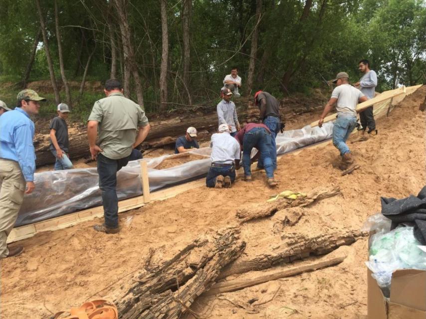 Un grupo de voluntarios, liderados por dos arqueólogos, protegen la canoa
