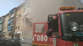Los bomberos tratan de apagar el fuego de la vivienda de Málaga.