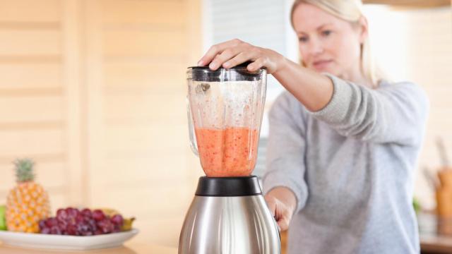 Side view of blender chopping fruits