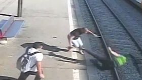 Momento en que el vigilante es empujado a las vías del tren por el agresor