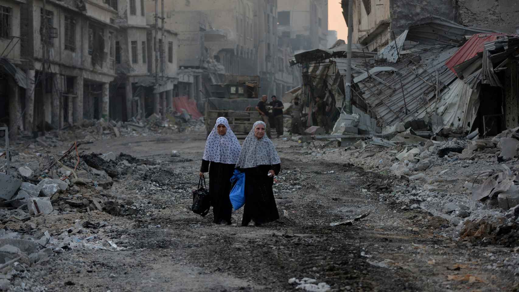 Dos mujeres desplazadas caminan entre los escombros de Mosul