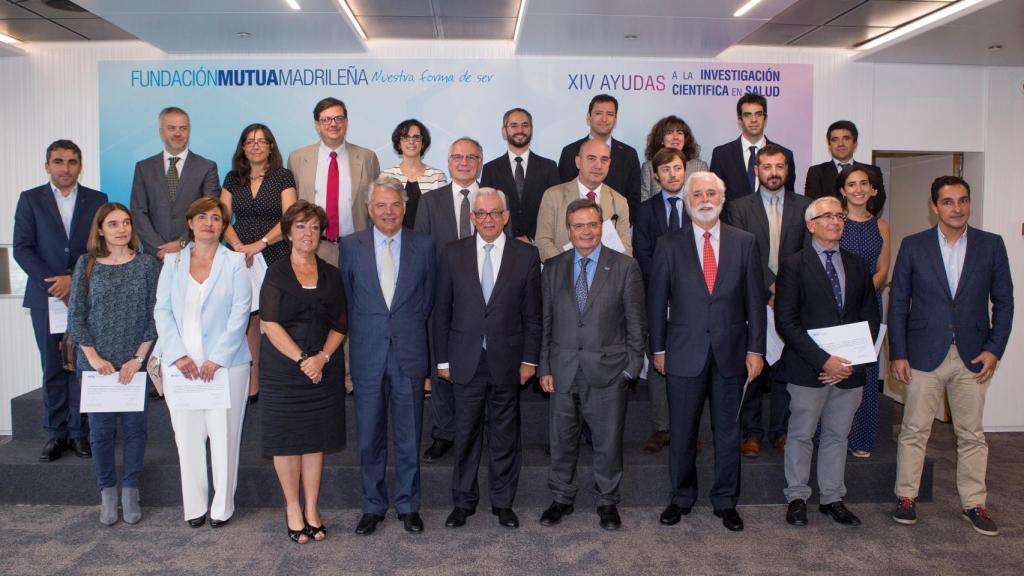 Foto de familia del acto en la que aparecen en el centro la directora general de Salud Pública, Calidad e Innovación del Ministerio de Sanidad, Servicios Sociales e Igualdad, Elena Andradas, el presidente del Grupo Mutua Madrileña y de su Fundación, Ignacio Garralda, el consejero de Sanidad de la Comunidad de Madrid, Jesús Sánchez Martos, y el presidente del Comité Científico de la Fundación Mutua, Rafael Matesanz, en el centro, junto a los investigadores beneficiarios de las ayudas.