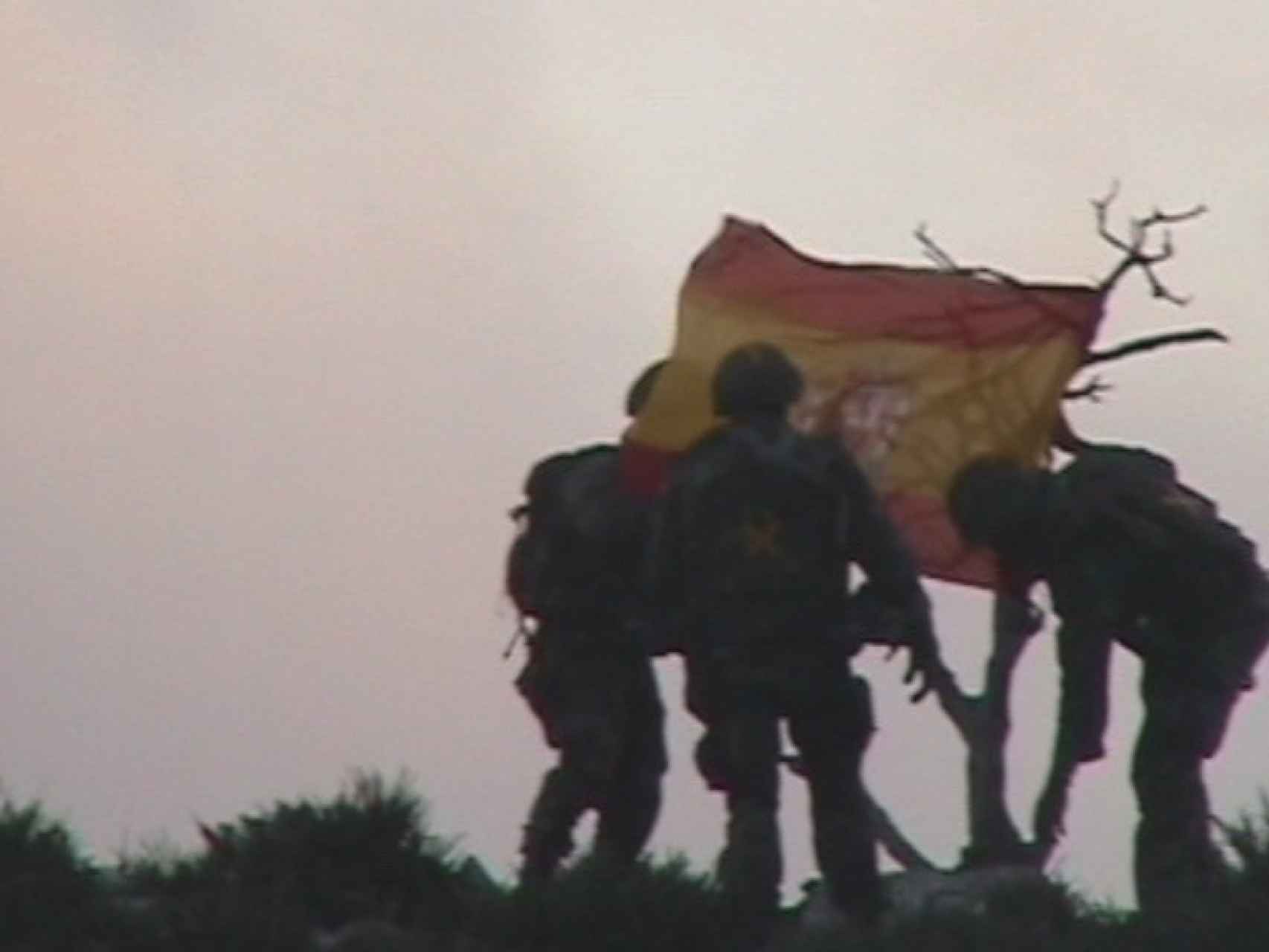 Los soldados de la misión plantan la bandera española en el islote.