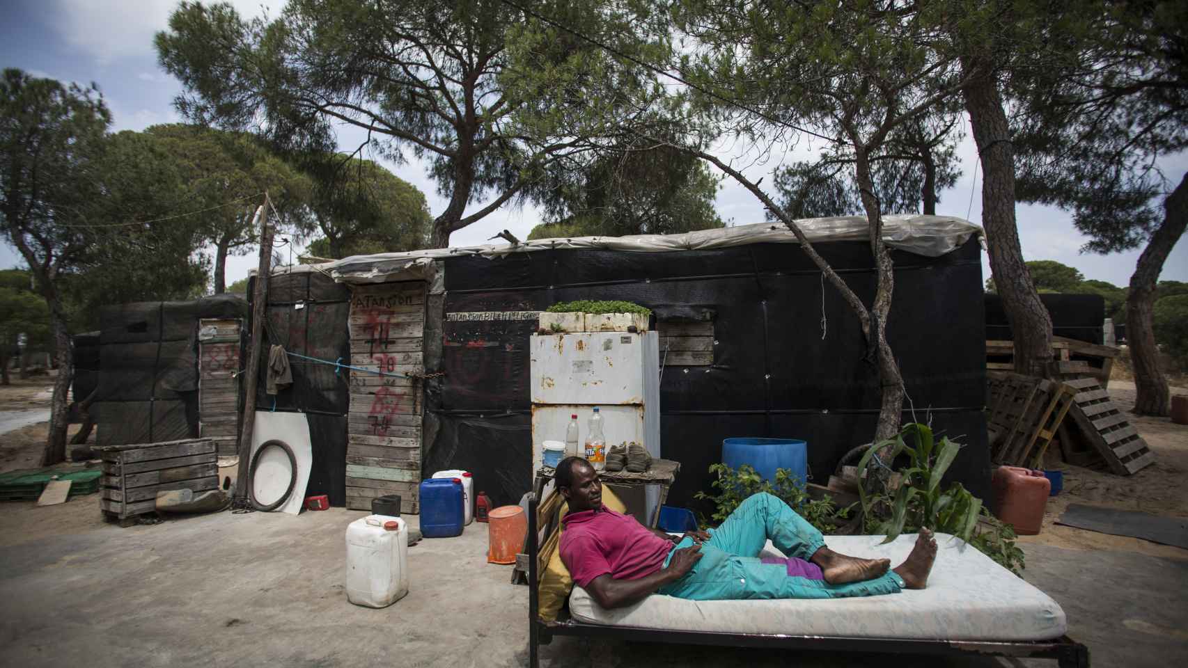 Issa Diakite Di Biletti descansando en el exterior de su chabola en el campamento de Las Madres (Huelva). Foto: Fernando Ruso